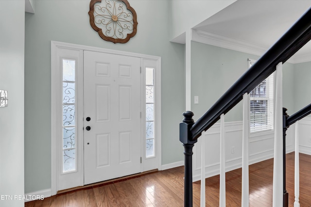 entryway with wood-type flooring and ornamental molding