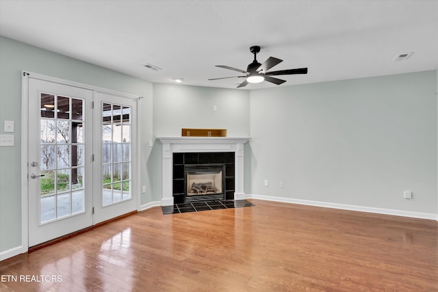 unfurnished living room featuring a fireplace, hardwood / wood-style floors, and ceiling fan