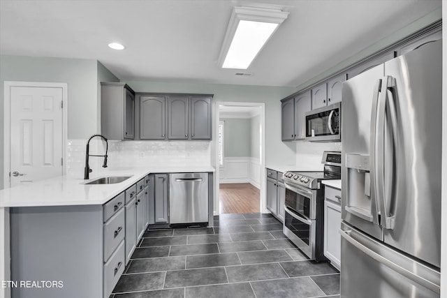 kitchen featuring gray cabinets, sink, dark tile patterned floors, and stainless steel appliances