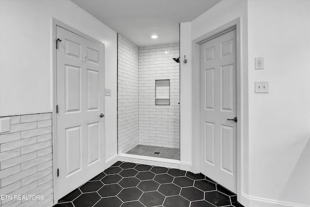 bathroom with tile patterned floors and tiled shower