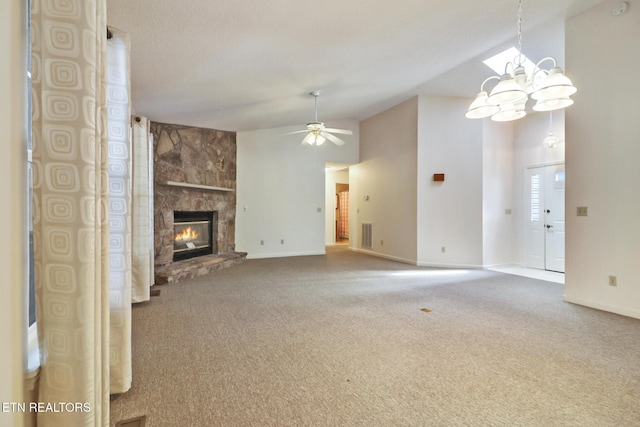 unfurnished living room with carpet flooring, a stone fireplace, high vaulted ceiling, and ceiling fan with notable chandelier