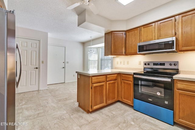 kitchen featuring kitchen peninsula, appliances with stainless steel finishes, a textured ceiling, and ceiling fan