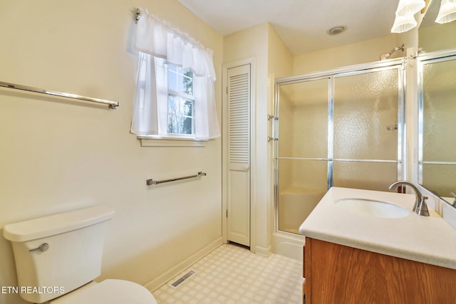 bathroom featuring vanity, toilet, and a shower with door