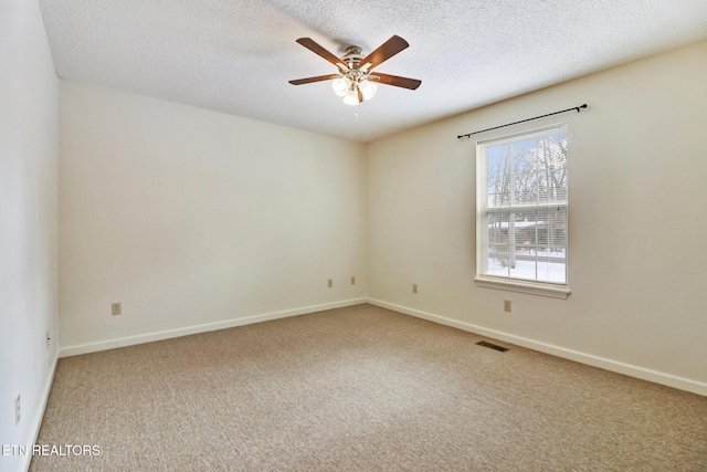 spare room with carpet, a textured ceiling, and ceiling fan