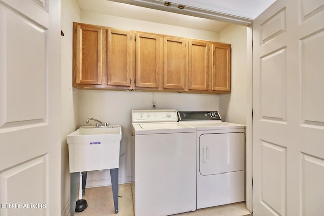 laundry room featuring washer and dryer and cabinets