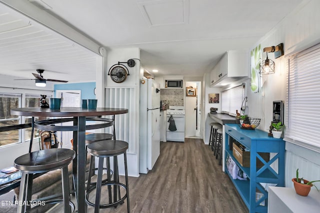 kitchen featuring tasteful backsplash, dark wood-style floors, white cabinetry, white appliances, and ceiling fan
