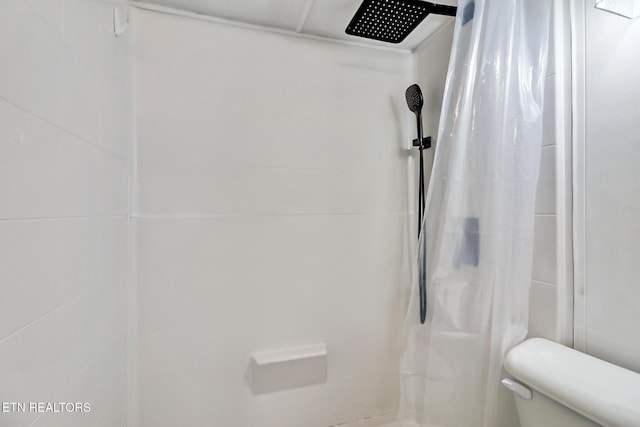 bathroom featuring curtained shower and toilet