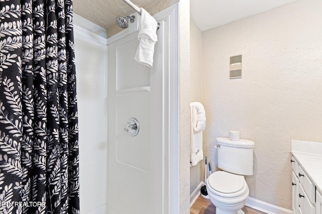 bathroom with a shower with curtain, vanity, wood-type flooring, and toilet