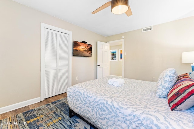 bedroom featuring hardwood / wood-style flooring, ceiling fan, and a closet