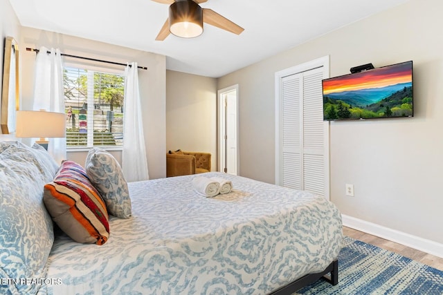 bedroom with a closet, hardwood / wood-style flooring, and ceiling fan