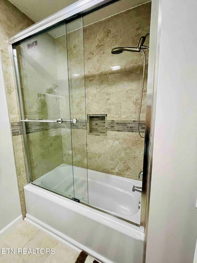 bathroom featuring tile patterned floors and bath / shower combo with glass door