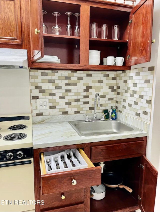 kitchen featuring tasteful backsplash, electric range, and sink