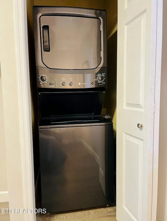 clothes washing area with stacked washer / dryer