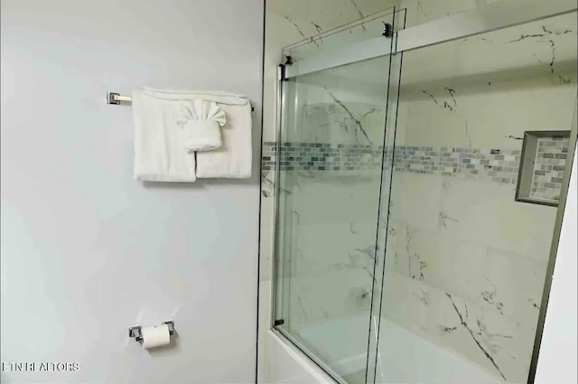 bathroom featuring shower / bath combination with glass door