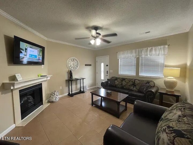 living room featuring ceiling fan, light tile patterned floors, a textured ceiling, and ornamental molding