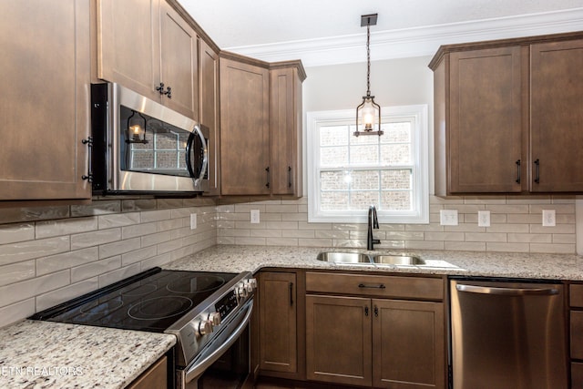 kitchen featuring appliances with stainless steel finishes, crown molding, a sink, and tasteful backsplash