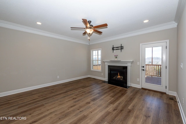 unfurnished living room with wood finished floors, ornamental molding, and a fireplace with flush hearth