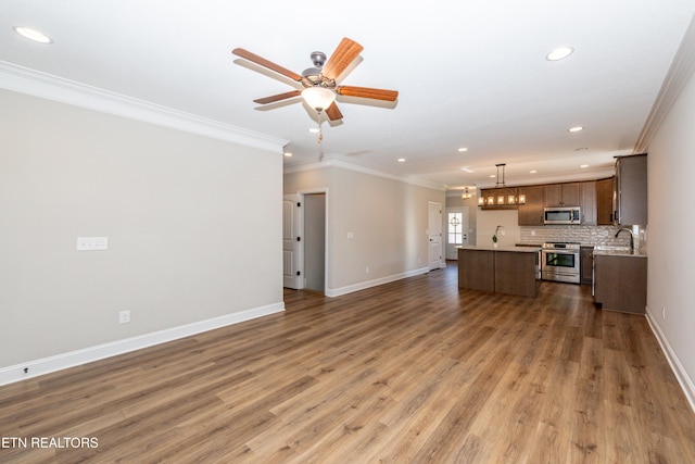 unfurnished living room with crown molding, baseboards, and wood finished floors