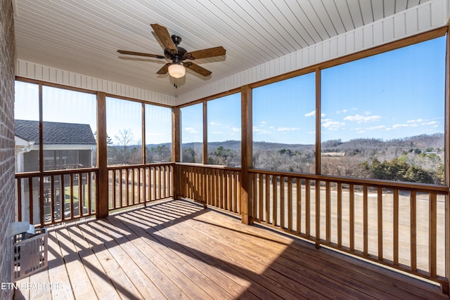 unfurnished sunroom with ceiling fan