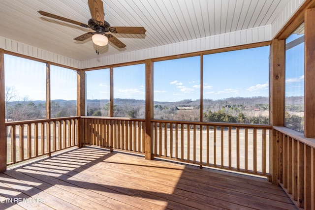 unfurnished sunroom featuring a ceiling fan