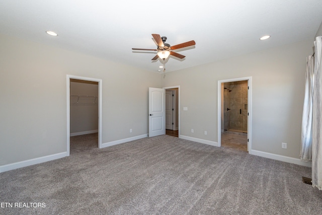 unfurnished bedroom with recessed lighting, a closet, a spacious closet, carpet flooring, and baseboards