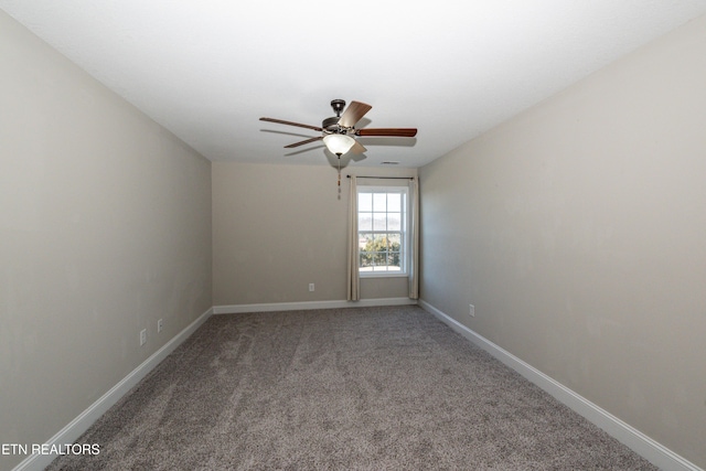 unfurnished room featuring a ceiling fan, carpet, and baseboards