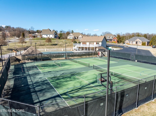 view of sport court with a residential view and fence