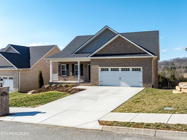 view of front of home featuring driveway, an attached garage, a front yard, a porch, and brick siding