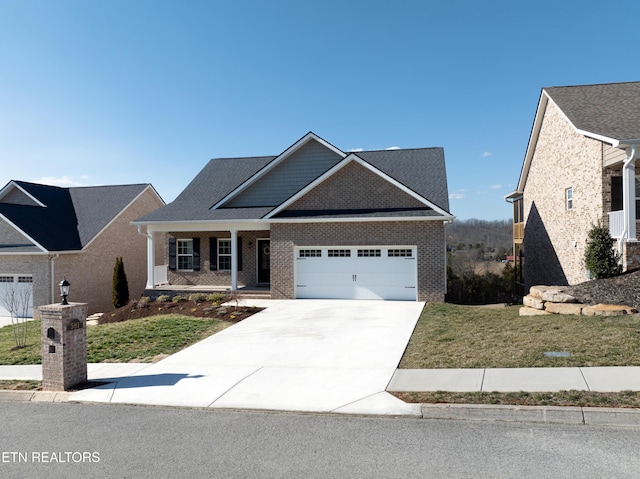 craftsman-style home with a garage, concrete driveway, brick siding, and a front lawn