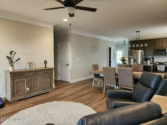 living room with ceiling fan, recessed lighting, wood finished floors, baseboards, and ornamental molding