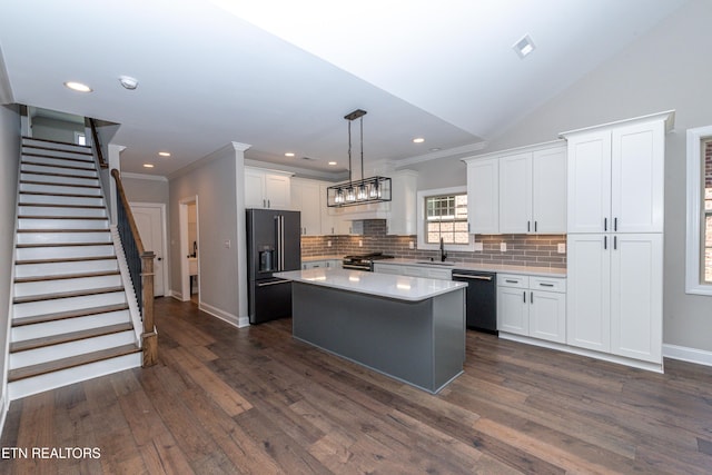 kitchen with white cabinetry, black appliances, a center island, decorative backsplash, and baseboards
