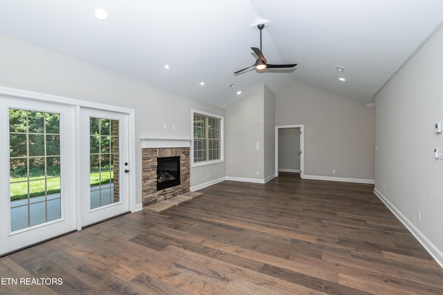 unfurnished living room with baseboards, a ceiling fan, a fireplace, wood finished floors, and vaulted ceiling