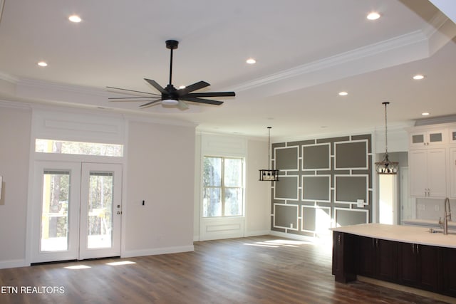 kitchen featuring crown molding, white cabinets, dark hardwood / wood-style floors, and a raised ceiling