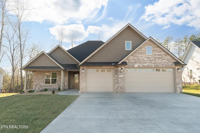 craftsman inspired home featuring a garage, a front yard, concrete driveway, and brick siding