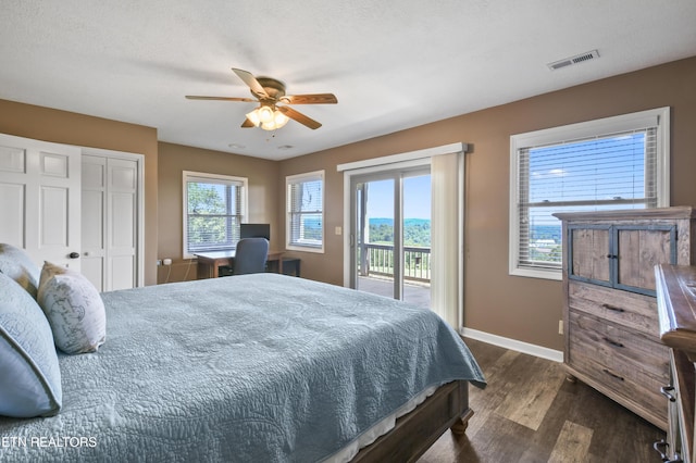 bedroom with access to exterior, a textured ceiling, ceiling fan, dark wood-type flooring, and a closet