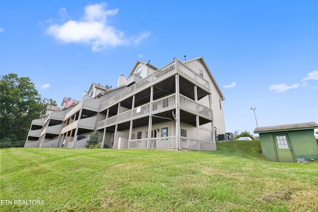 rear view of property with a yard and central AC unit