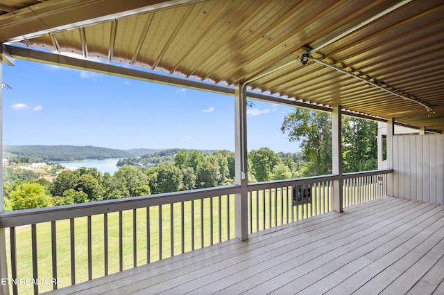 wooden deck with a lawn and a water view