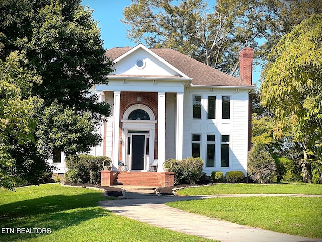 greek revival inspired property with a front lawn