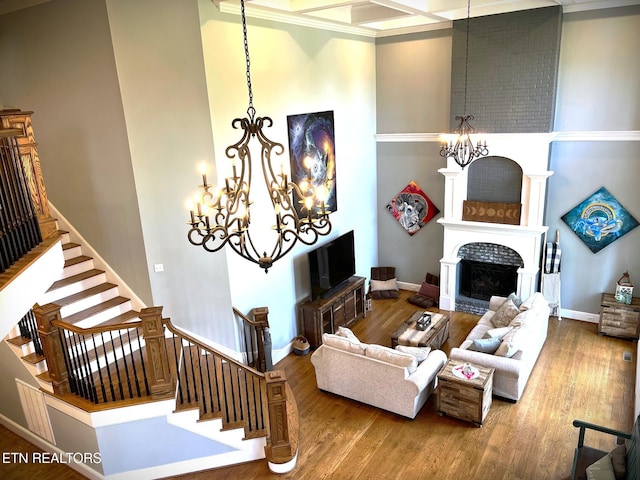 living room with ornamental molding, hardwood / wood-style floors, and a notable chandelier