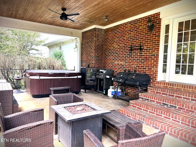 view of patio / terrace with a grill, a hot tub, ceiling fan, and an outdoor fire pit