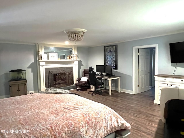 bedroom featuring crown molding, a fireplace, and dark hardwood / wood-style flooring