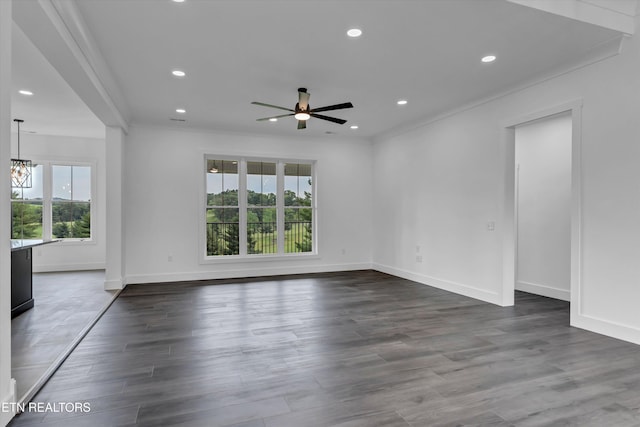 unfurnished room with crown molding, dark wood-type flooring, and ceiling fan with notable chandelier