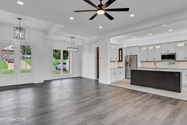 unfurnished living room featuring ceiling fan, french doors, and hardwood / wood-style flooring