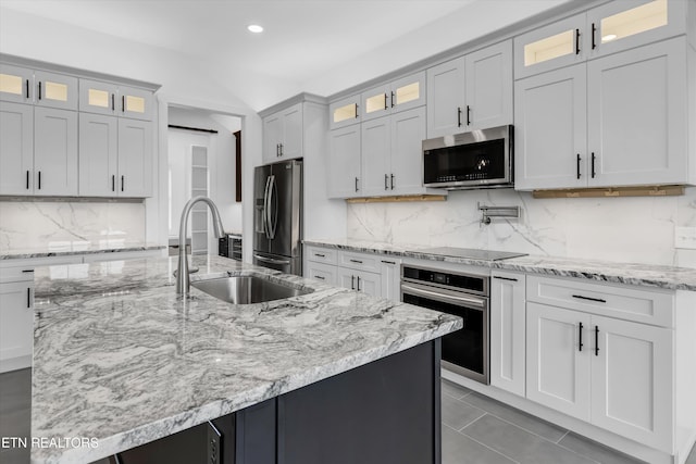 kitchen featuring tasteful backsplash, sink, an island with sink, and stainless steel appliances