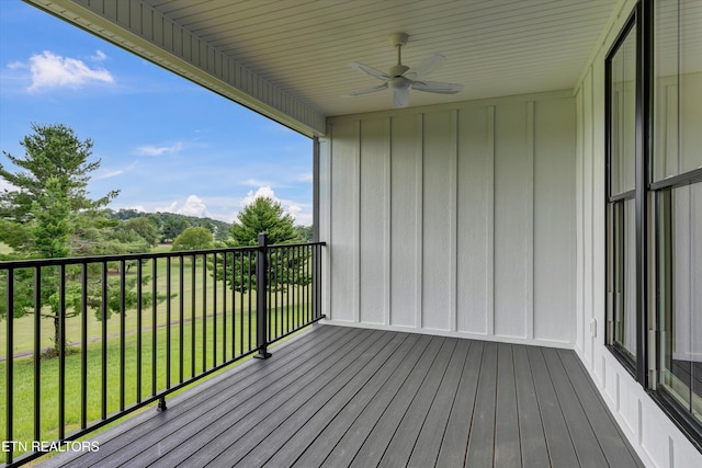 wooden deck featuring a lawn and ceiling fan