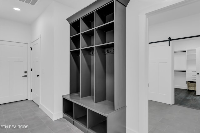 mudroom featuring a barn door and tile patterned flooring