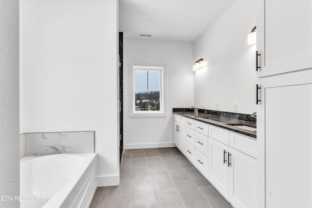 bathroom with tile patterned flooring, vanity, and a bathing tub