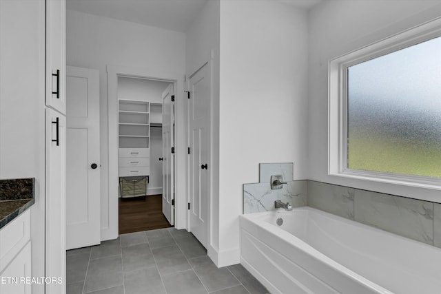 bathroom featuring tile patterned flooring, vanity, a bathtub, and plenty of natural light