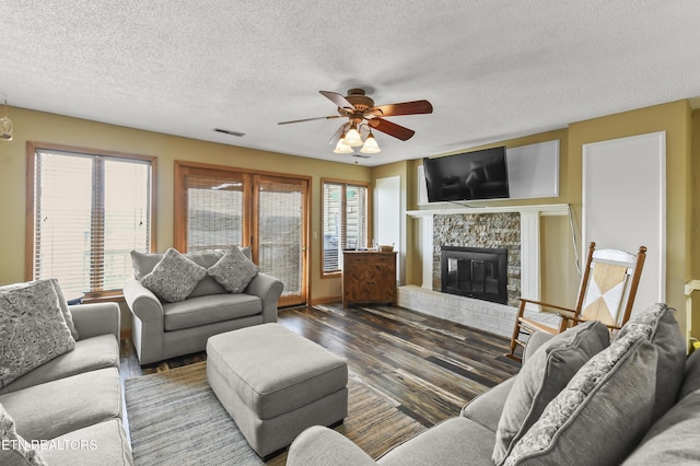 living room with ceiling fan, dark hardwood / wood-style floors, and a textured ceiling