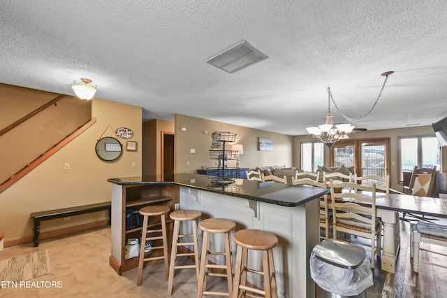 kitchen with a healthy amount of sunlight, decorative light fixtures, a kitchen breakfast bar, and kitchen peninsula